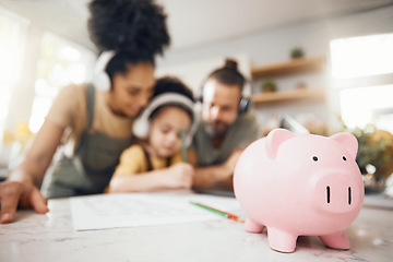 Image showing Piggy bank, table and parents with child, learning and writing with headphones, paper and saving advice. Mom, dad and kid for education, investing and helping for future in interracial family house