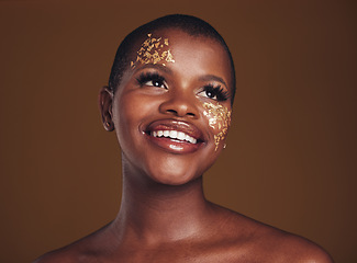 Image showing Gold flakes, makeup and woman beauty with a smile from luxury treatment and facial spa. Glitter art, creative dermatology and African female person from skincare and golden cosmetics in studio