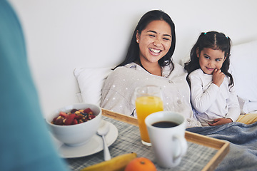 Image showing Mother and daughter with breakfast in bed while relaxing for mothers day surprise at home. Happy, smile and young mom resting with girl child with a healthy meal for brunch on weekend at their house.