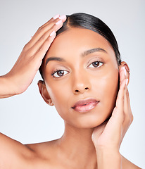 Image showing Portrait of Indian woman with hands for skincare, beauty and cosmetics on white background for facial. Dermatology, spa and serious face of isolated person for wellness, self care or health in studio