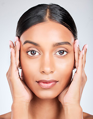 Image showing Studio portrait of Indian woman with hands for skincare, beauty and cosmetics on white background. Dermatology, spa and serious face of isolated person for wellness, satisfaction and facial treatment