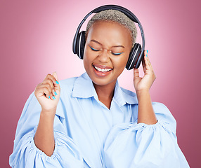 Image showing Headphones, dance and happy black woman in studio with music, radio or streaming subscription on pink background. Podcast, earphones or African lady model dancing to album track or feel good playlist