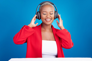 Image showing Music, headphones and black woman dance in studio celebration with news, feedback or promo on blue background. Freedom, happy and African model dancing to earphones radio, podcast or audio streaming