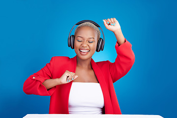 Image showing Music, dance and black woman with headphones in studio celebration with news, feedback or promo on blue background. Freedom, happy and African lady dancing to earphones radio, podcast or streaming