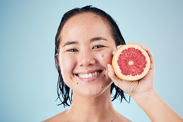 Image showing Portrait, smile or happy woman with grapefruit for skincare or beauty in studio on blue background. Results, dermatology or Asian person with natural fruits, vitamin c or glowing face for wellness