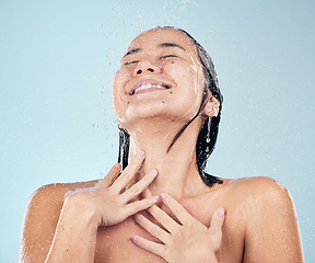 Image showing Skincare, shower and happy woman cleaning in studio isolated on a blue background. Water splash, hygiene and model smile, washing and bathing in wellness, healthy skin beauty of body in bathroom.