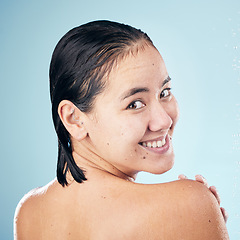 Image showing Shower, portrait or happy woman cleaning back, hair or body for wellness in studio on blue background. Smile, beauty or wet person washing or grooming for healthy natural hygiene or skincare to relax