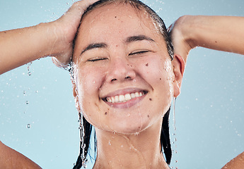 Image showing Shower, face or happy woman cleaning hair for skincare or wellness in studio on blue background. Shampoo, beauty model or wet female person washing or grooming for healthy natural hygiene to relax