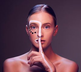 Image showing Woman, face and paint in finger, lips or studio for art, secret or cosmetic for fantasy by dark background. Girl, model and facial painting with hush sign, mouth or creativity with makeup in portrait