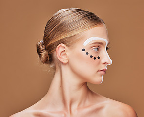 Image showing Art, cosmetic and young woman in studio with creative, beauty and abstract face aesthetic. Makeup, artistic and headshot of gen z female model from Australia with facial paint by brown background.