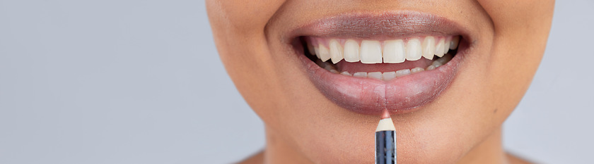 Image showing Makeup, beauty and lips of woman with pencil in studio for wellness, skincare product and cosmetics. Salon, banner and face zoom of person with lipstick or lip liner for glamour, makeover and glow