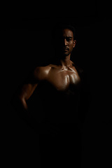 Image showing Topless, muscle and portrait man in dark background for fitness inspiration, beauty aesthetic or strong body. Shadow aesthetic, topless male model or body builder in creative studio with art lighting