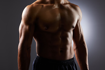 Image showing Topless, muscle and torso of man in dark background for fitness inspiration, beauty aesthetic or strong body. Shadow aesthetic, male sports model or muscular body builder in studio with art lighting.