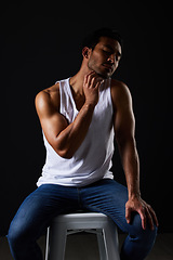 Image showing Sexy muscular man on chair in studio with fitness inspiration, beauty aesthetic and sensual fashion. Erotic art, sexual body and male model sitting on black background, thinking in dark lighting.