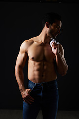 Image showing Sexy, muscle and man in studio with fitness inspiration, beauty aesthetic and ashion. Strong art, healthy body and male model on black background, thinking in dark lighting with jeans and abs