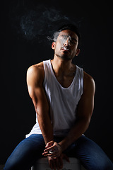 Image showing Smoking, sexy man and chair on black background in fitness inspiration, beauty aesthetic and sensual fashion. Erotic art, sexual body and male model with muscle, cigarette and studio in dark lighting