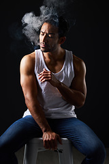 Image showing Smoke, thinking and sexy man on chair in studio in fitness, beauty aesthetic and sensual fashion. Erotic art, sexual body and male model with muscle, cigarette and black background in dark lighting.