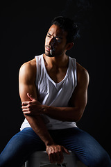 Image showing Smoking, thinking and sexy man on chair in studio in fitness, beauty aesthetic and sensual fashion. Erotic art, sexual body and male model with muscle, cigarette and black background in dark lighting