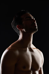 Image showing Bodybuilder man, muscle and shadow in studio with wellness, healthy body and black background. Young guy, fitness and silhouette in dark, thinking and strong with ideas, health and shirtless for art