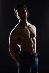 Image showing Bodybuilder man, topless and muscle in studio for wellness, healthy body and black background. Young guy, fitness and silhouette in jeans, portrait and strong for fashion, shadow or shirtless for art