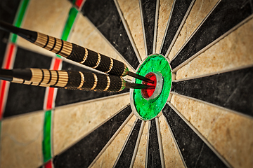 Image showing Three darts in bull's eye close up