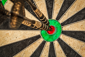 Image showing Three darts in bull's eye close up