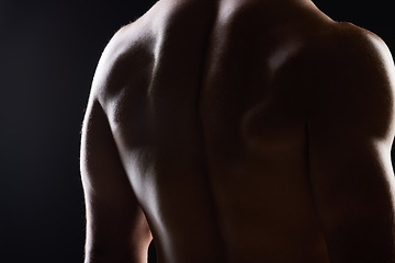 Image showing Strong back, dark studio and person with ripped body, fitness transformation goals and muscle building results. Bodybuilder training exercise, shadow light and muscular athlete on black background