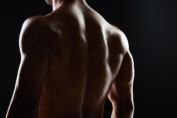 Image showing Man, back and muscle with silhouette, studio and shadow for wellness, health and strong by black background. Bodybuilder guy, shirtless and fitness with skin, aesthetic and power in dark for art