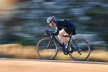 Image showing Motion blur, speed and cyclist on bicycle on road in mountain with helmet, exercise adventure trail and fitness. Cycling race, nature and man with bike for fast workout, training motivation or energy