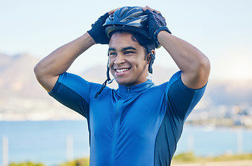 Image showing Cycling helmet, exercise and a man outdoor for sports, workout or training with a happy smile. face of a young athlete or cyclist with safety, wellness and fitness at park or thinking of performance