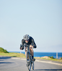 Image showing Speed, fitness and cyclist on bicycle on road in mountain with blue sky, exercise adventure trail and speed. Cycling race, nature and man with bike for fast workout, training motivation or energy.