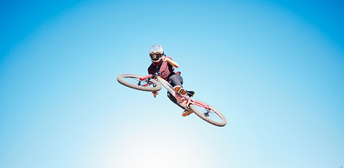 Image showing Sky, cycling and a person jump outdoor for sports, workout or training with skills and stunt. Athlete or cyclist with safety, wellness and fitness or banner space with balance and bicycle in air