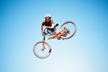 Image showing Cycling, sky and a man jump outdoor for sports, workout or training with skills and stunt. Athlete or cyclist with safety, wellness and fitness or performance space with balance and bicycle in air
