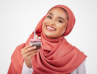 Image showing Portrait, candle in a cupcake and an islamic woman in studio on white background for dessert. Face, smile and food with a happy young muslim person eating a cake, candy or sugar snack in celebration