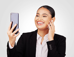 Image showing Video call, phone and earphones with a business woman in studio on a white background for communication. Smile, networking and music with a happy young employee reading a text message on her mobile
