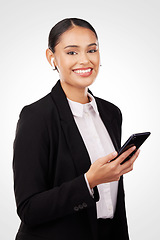 Image showing Portrait, phone and earphones with a business woman in studio on a white background for communication. Smile, networking and music with a happy young employee typing a text message on her mobile