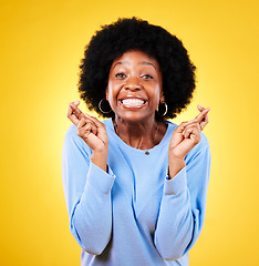 Image showing Woman, fingers crossed and excited portrait in studio for hope, trust and optimism for winning, prize and lottery. African model wish for luck, bonus promotion or giveaway winner on yellow background