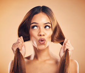 Image showing Face pucker, beauty or woman with hair care, healthy shine and strong extensions, volume or keratin results. Hairdressing, facial expression or natural model with studio hairstyle on brown background