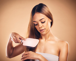 Image showing Hair, brush and a woman in studio for beauty, cosmetics and shine. Aesthetic model person on brown background for wellness, healthy growth and hairdresser or salon results with self care benefits