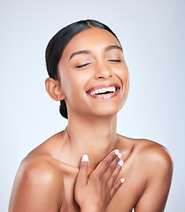 Image showing Face, skincare and smile with a woman laughing for health, wellness or dermatology in studio on white background. Skincare. funny and a happy young model feeling satisfaction at her cosmetic routine