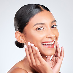 Image showing Portrait, happy woman and touch face in studio for pride in skincare, aesthetic glow or healthy dermatology on white background. Young indian model, natural beauty and smile for clean facial cosmetic