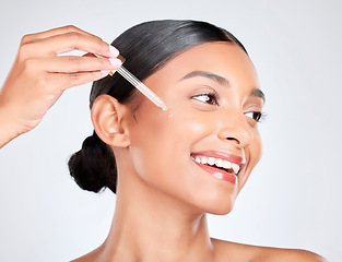 Image showing Happy, woman and pipette with skincare, oil and serum for beauty with wellness on white studio background. Person, cosmetic product or model with hyaluronic acid, luxury or shine with serum and glow