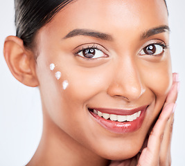 Image showing Portrait, cream and woman with cosmetics, smile and dermatology on a white studio background. Face, person and model with lotion, shine or creme with skincare, moisturiser and wellness with aesthetic