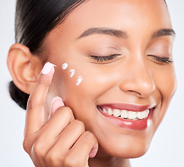 Image showing Cream, skincare and woman with dermatology, smile and wellness on a white studio background. Person, happy girl and model with creme, moisturiser and healthy skin with beauty, aesthetic and self care