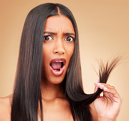Image showing Hair care, shock and portrait of woman in a studio with split ends for salon keratin treatment. Beauty, cosmetic and surprised Indian female model with hairstyle isolated by a brown background.