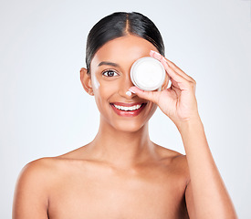 Image showing Woman, cream on face and container for beauty, moisturizer and skincare isolated on white background. Cosmetics product, lotion or sunscreen with smile, facial and skin with dermatology in studio