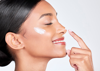 Image showing Face, cream and woman with skincare, beauty and self care on a white studio background. Person, profile and model with creme, sunscreen and wellness with grooming, shine and aesthetic with lotion
