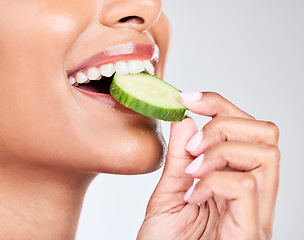 Image showing Woman, mouth and eating cucumber in studio closeup for health, diet and detox by white background. Girl, model and nutrition with fruit, vegetable and vegan food for beauty, skincare and wellness