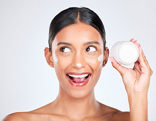Image showing Woman, happy surprise with cream on face and beauty, moisturizer and skincare with container on white background. Cosmetics product, lotion or sunscreen, facial and skin with dermatology in studio