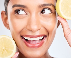 Image showing Lemon, fruit and face of Indian woman with skincare, beauty and benefits of vitamin c in eco friendly cosmetics in studio. Indian, model and thinking of dermatology with healthy and natural fruits